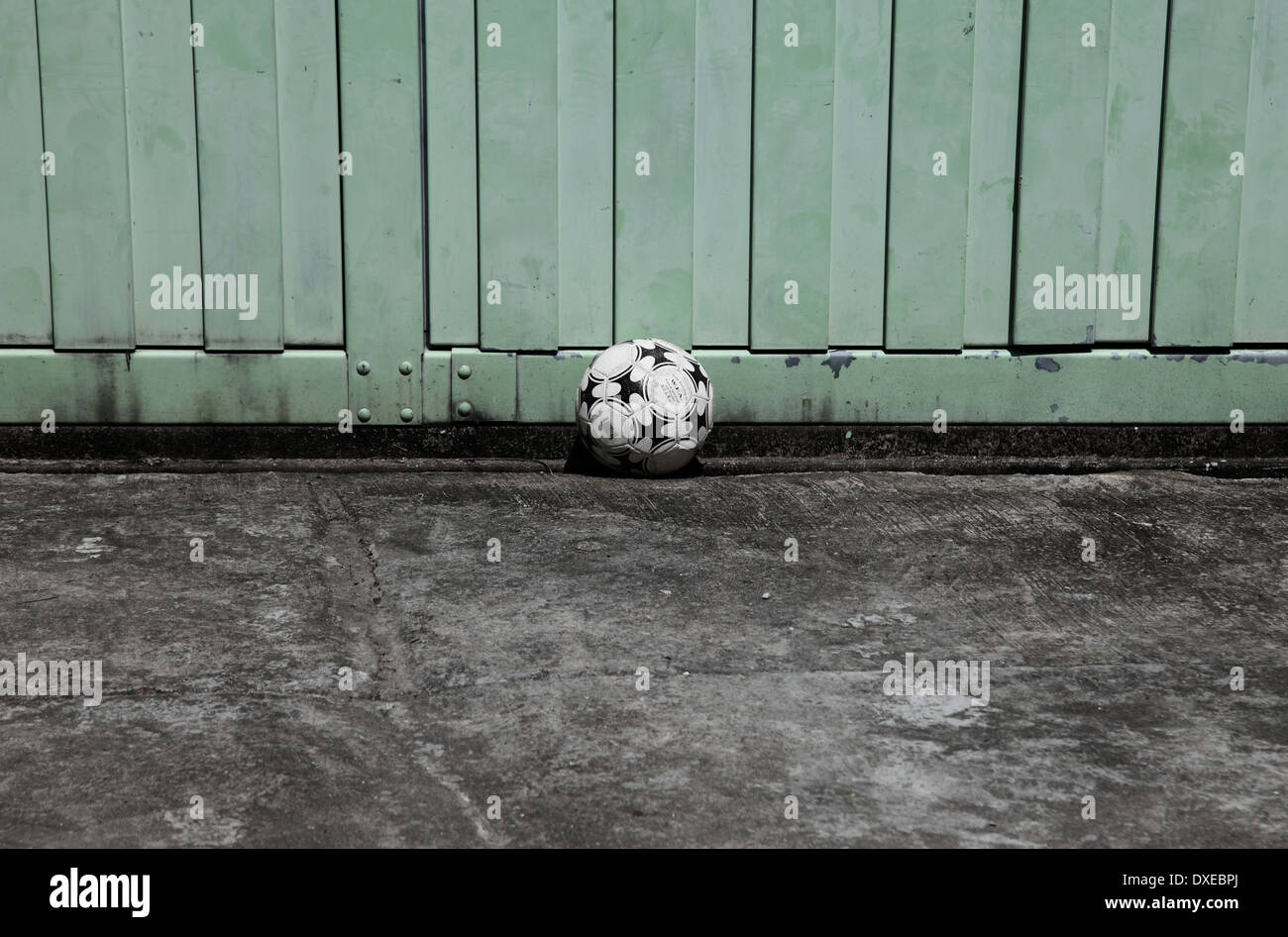 Es ist ein Foto von einem Basketball Ball auf einem rauhen Betonboden. Es ist ein Kind-Ball für Spiel und Spiele Stockfoto