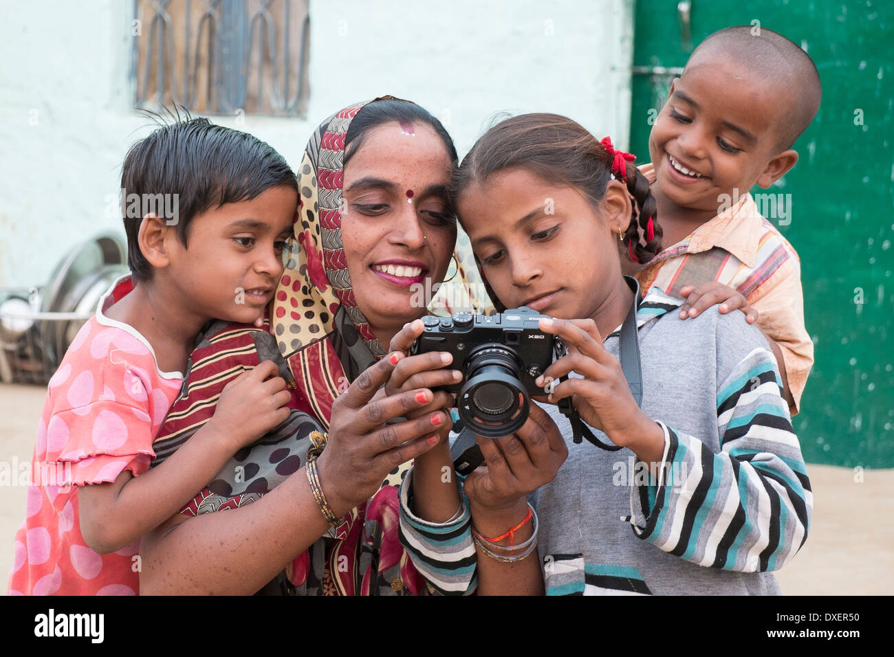 Indien, Uttar Pradesh, Agra, Mutter und drei Kinder auf der Suche auf der Rückseite einer modernen Digitalkameras Stockfoto