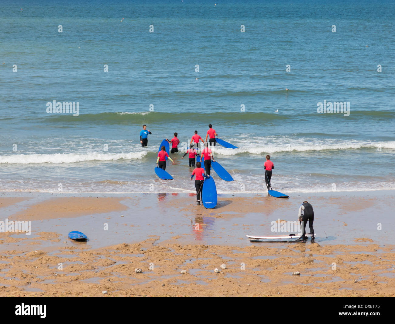 Schule für Surfer mit Passanten ins Meer tragen Surfbretter an Cromer Norfolk in England Stockfoto