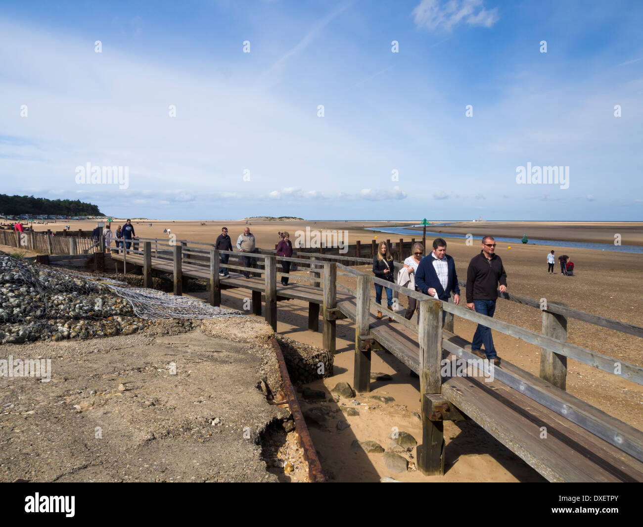 Menschen zu Fuß auf hölzernen Weg über den Strand am Brunnen als nächstes Meer Norfolk England Stockfoto