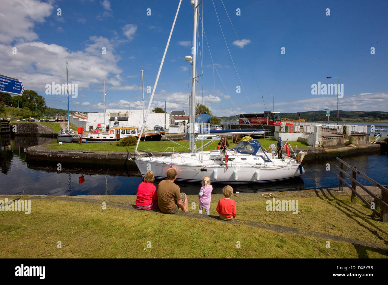 Besucher sehen eine Yacht, die Eingabe des Crinan Kanals von Loch Fyne bei Ardrishaig Becken, Argyll Stockfoto