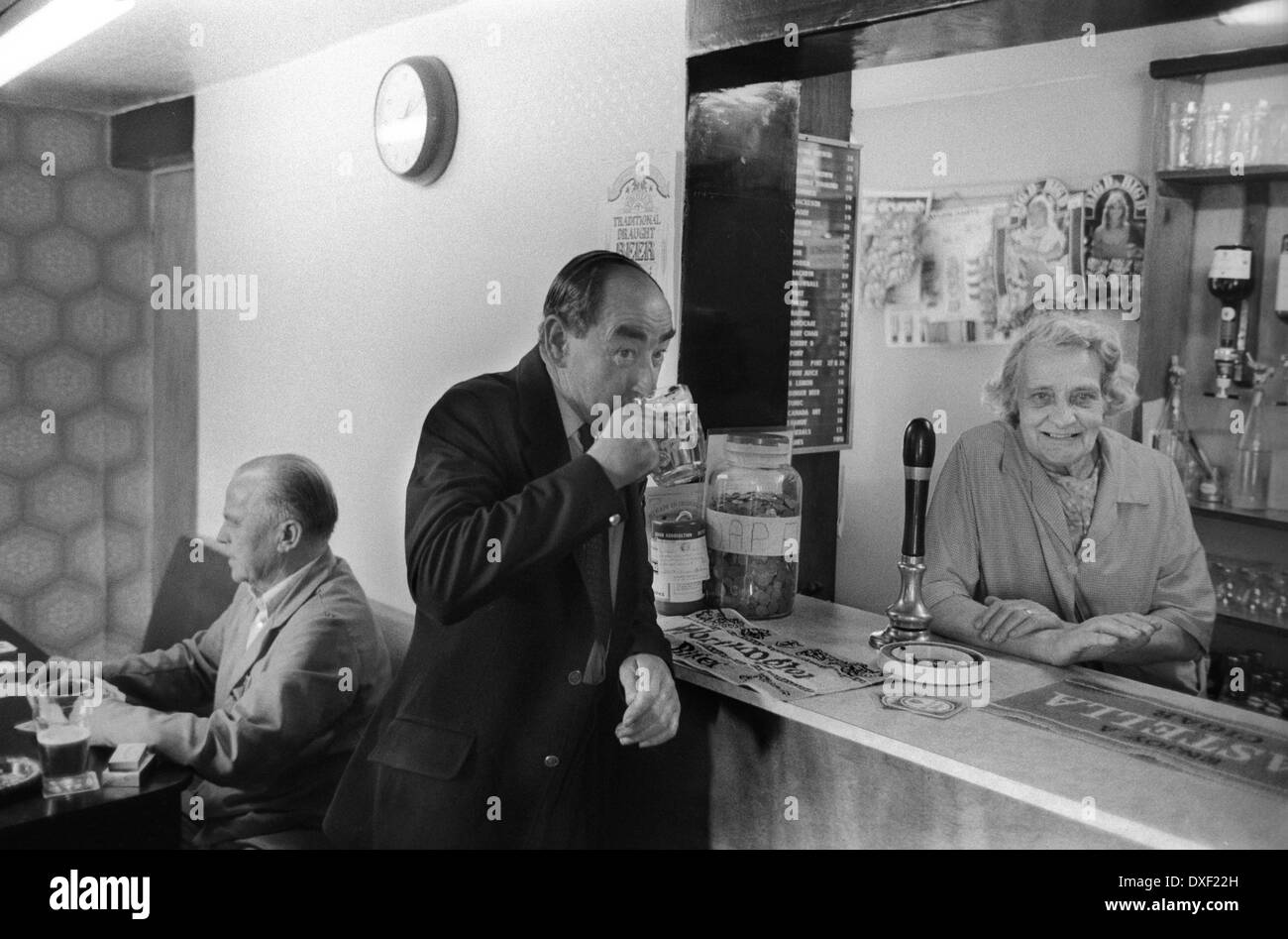 Ein Mann trinkt ein Bier. Pub Interior 1970s Shropshire Village Life Vermieterin Mrs Eliza Lewis und Gast an der Bar. All Nations Inn Pub, ein hausgemachter Pub. Madeley, Telford, Shropshire Großbritannien England 1978. HOMER SYKES Stockfoto