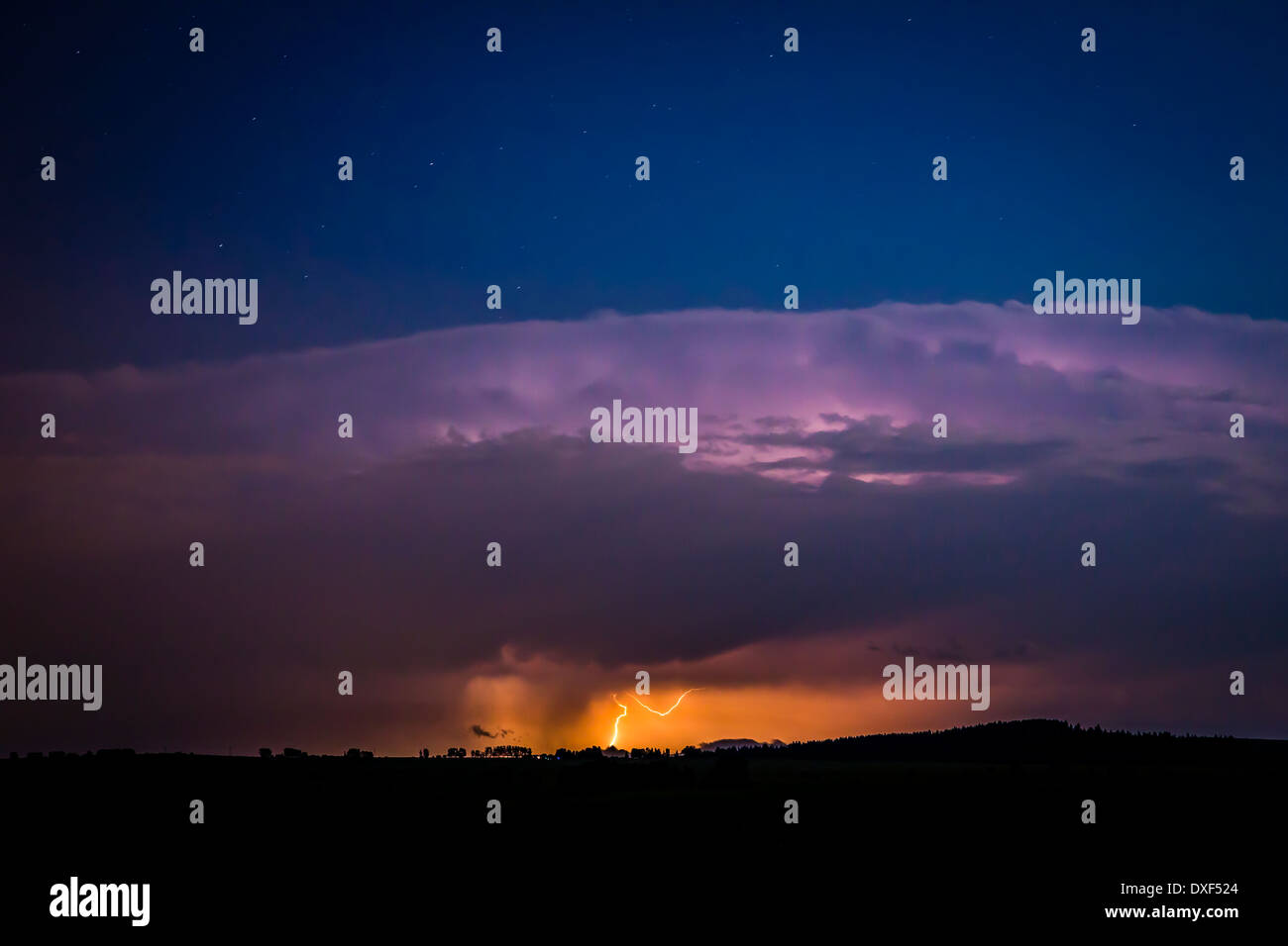 Ein Blitz schlägt die Prärie unter eine massive Gewitterwolke westlich von Calgary, Alberta, Kanada. Stockfoto