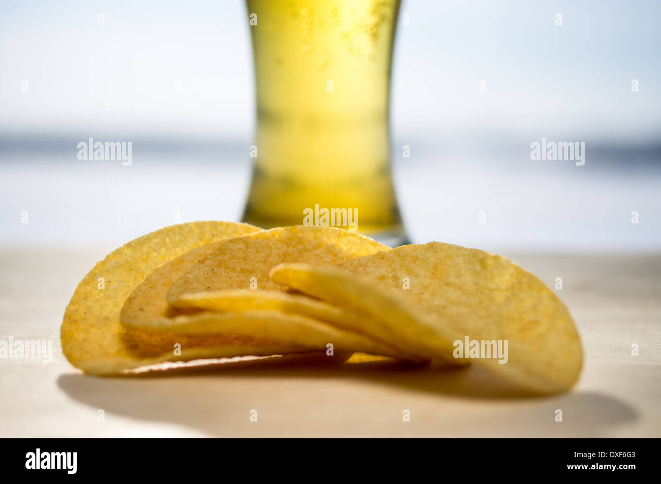 Pint Bier. Ein schäumendes Glas Bier und Chips im Hintergrund Stockfoto
