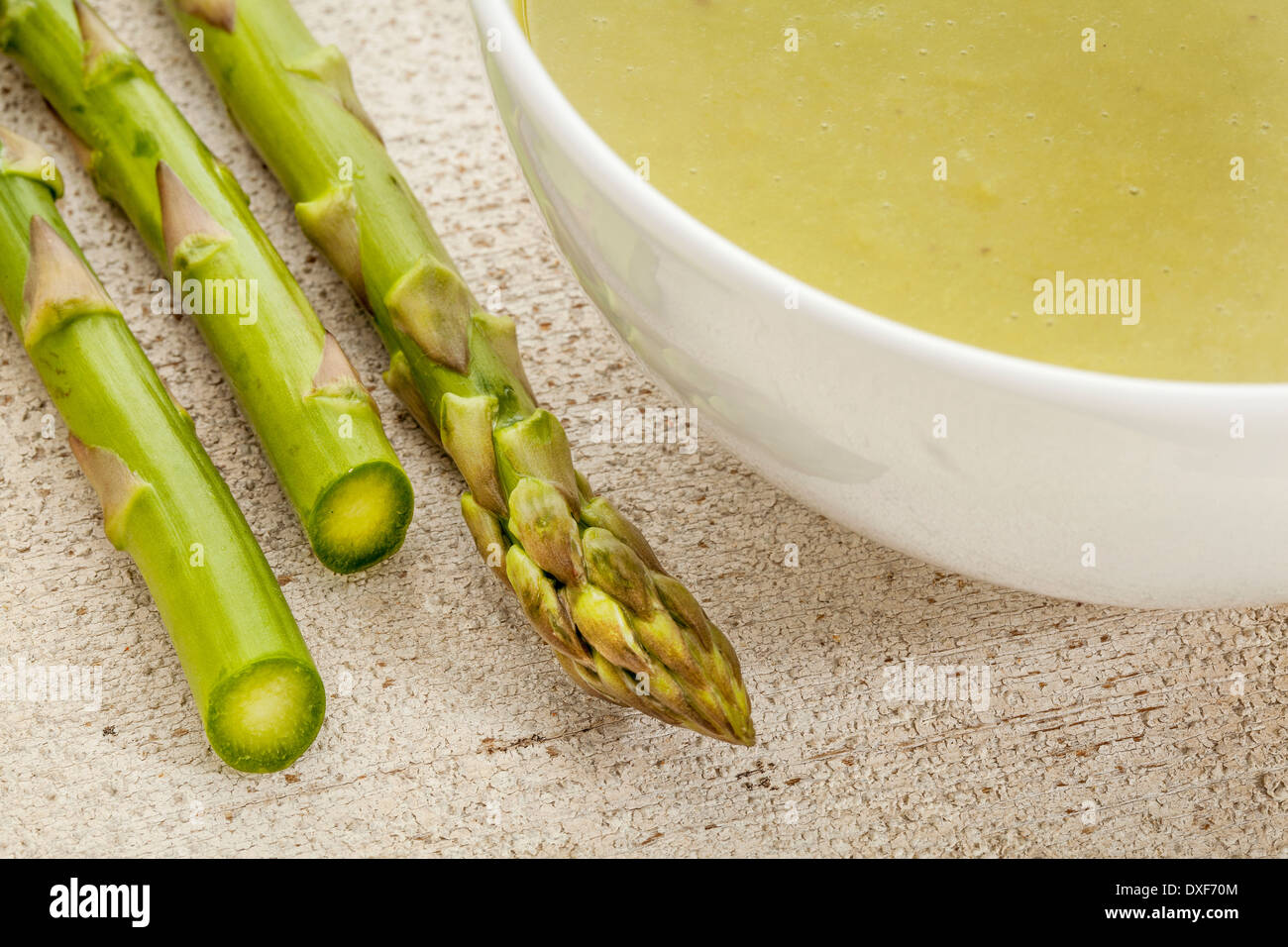 eine Schüssel mit Spargel-Creme-Suppe mit grünen Spargelspitzen Stockfoto