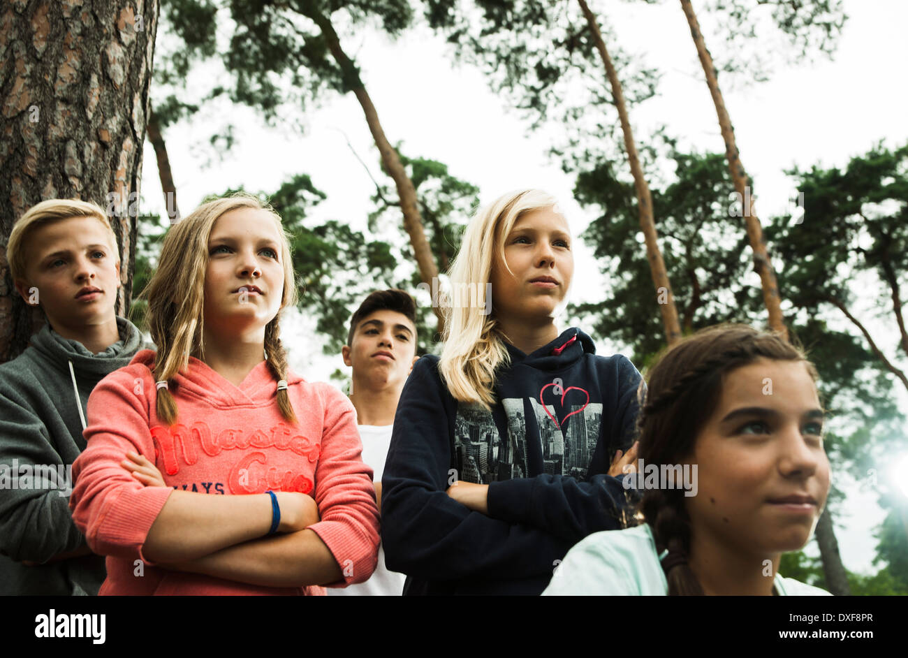 Porträt der Gruppe von Kindern stehen neben Bäumen im Park mit verschränkten Armen und wir freuen uns in dieselbe Richtung, Deutschland Stockfoto
