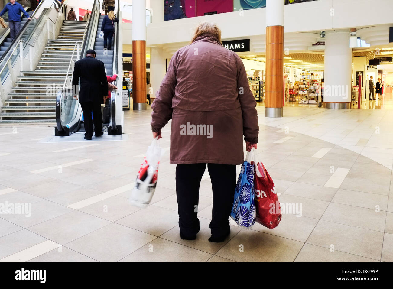 Rückansicht eines müden älteren Shoppers in einem Einkaufszentrum. Stockfoto