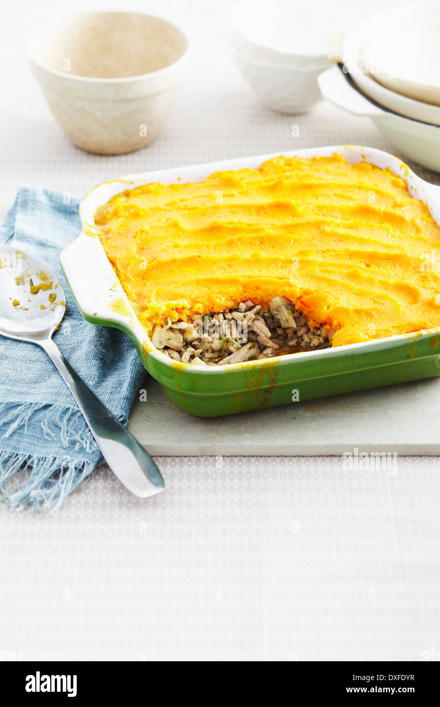 Shepherds Pie in Auflaufform auf Tisch mit Löffel serviert Stockfoto