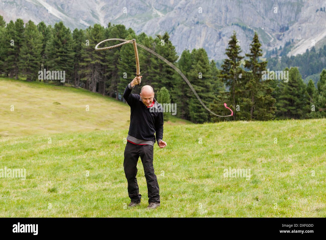 Mann Auspeitschen in der Luft, wie es Custume in den Alpen Stockfoto