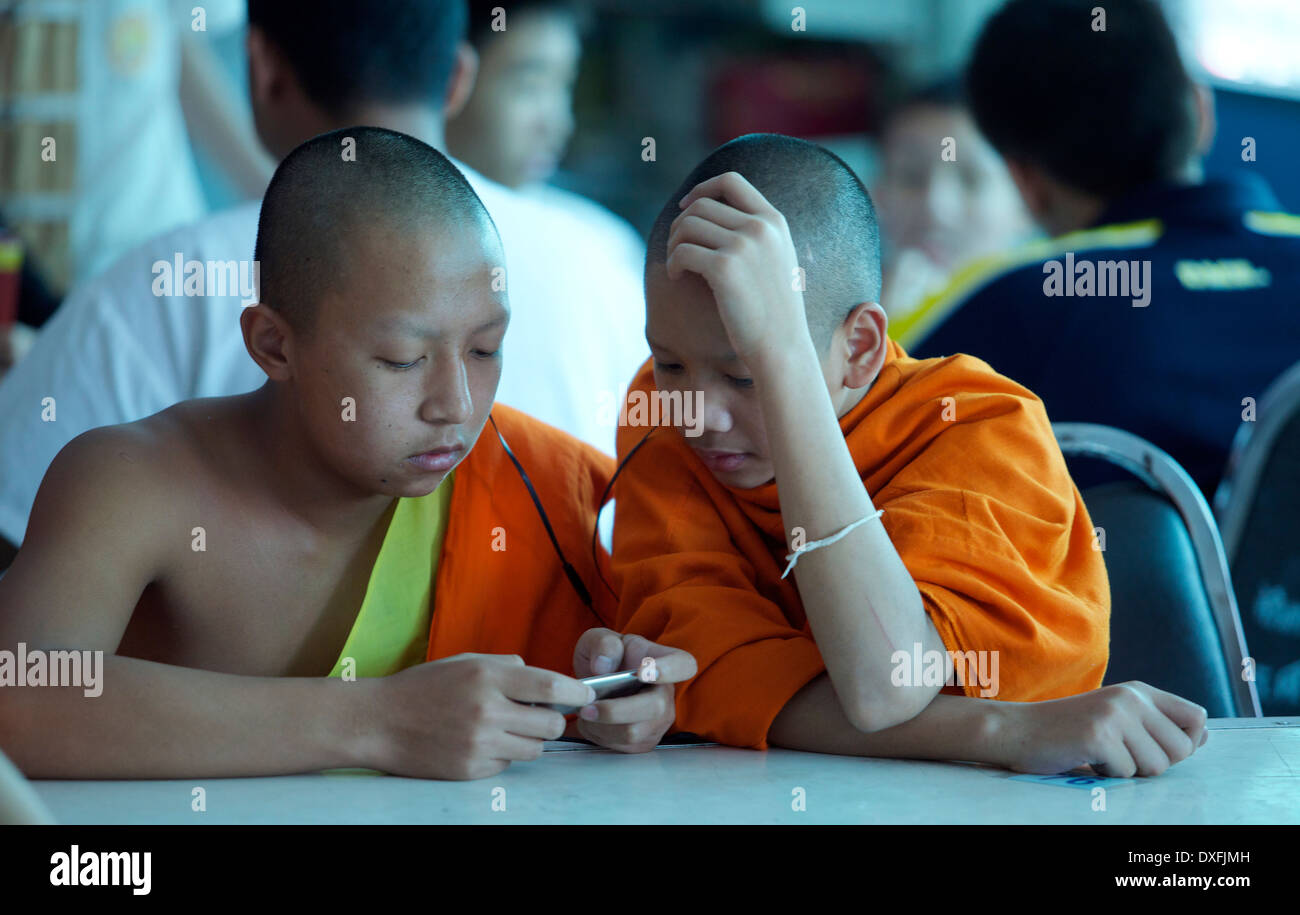 Junge Mönche Blick auf ein Gerät in einem Klassenzimmer Stockfoto
