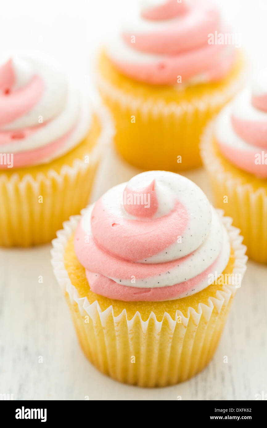 Vanille Cupcakes mit Erdbeer-Sahne gekrönt. Stockfoto