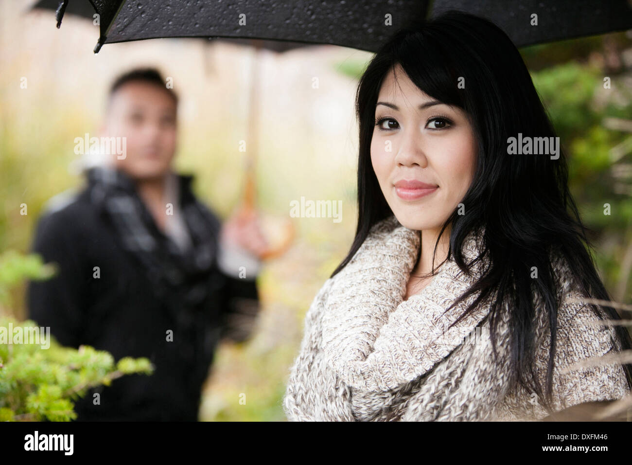 Close-up Portrait Frau unter Dach mit Mann im Hintergrund, Ontario, Kanada Stockfoto
