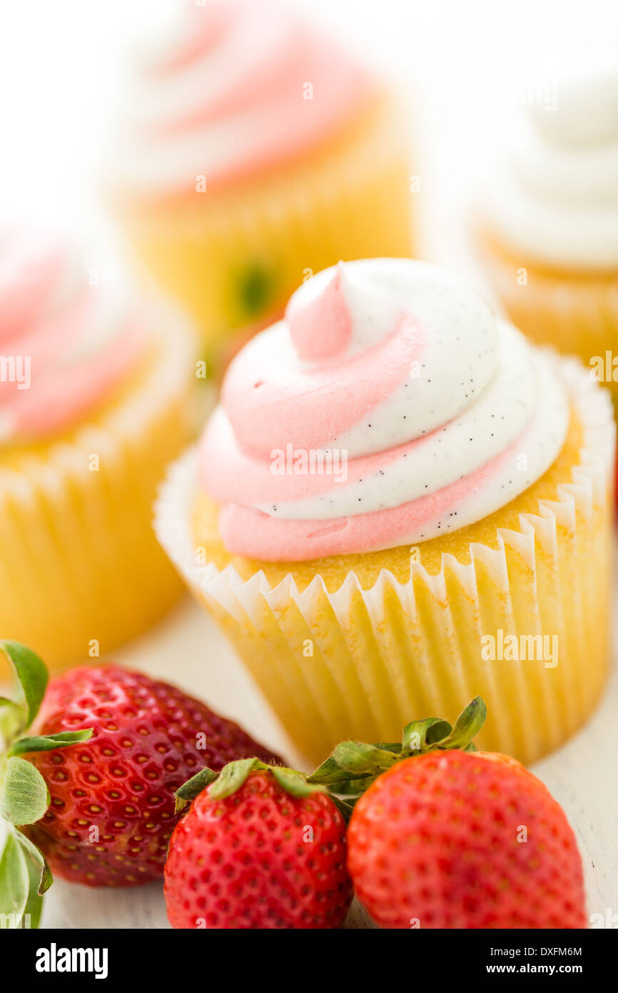 Vanille Cupcakes mit Erdbeer-Sahne gekrönt. Stockfoto