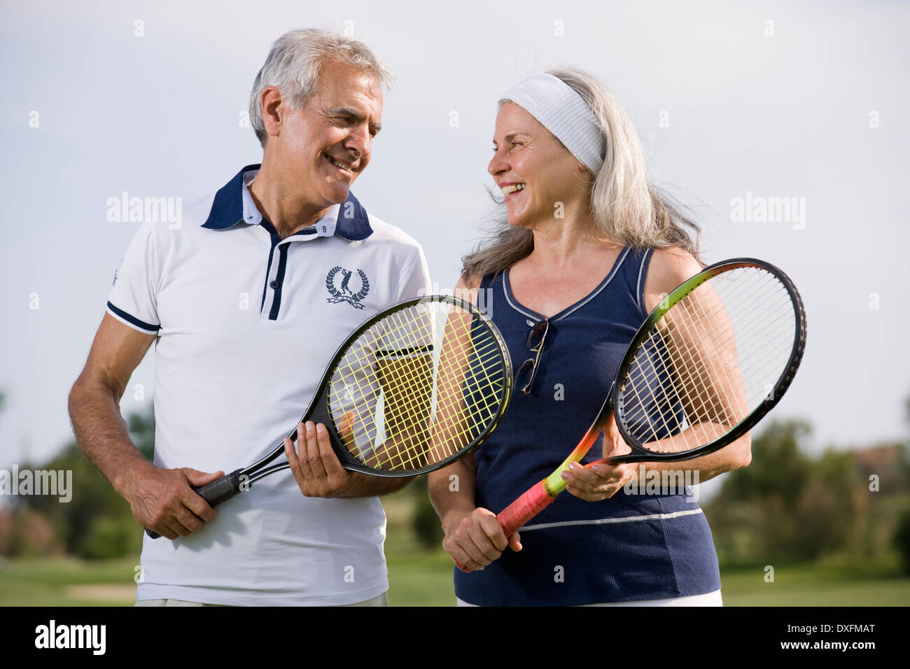 Älteres Paar halten Tennisschläger Stockfoto