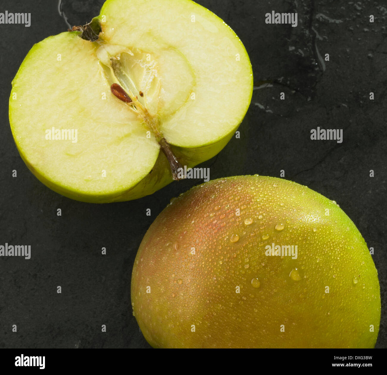Halbierter Apfel auf Schiefer Hintergrund Stockfoto