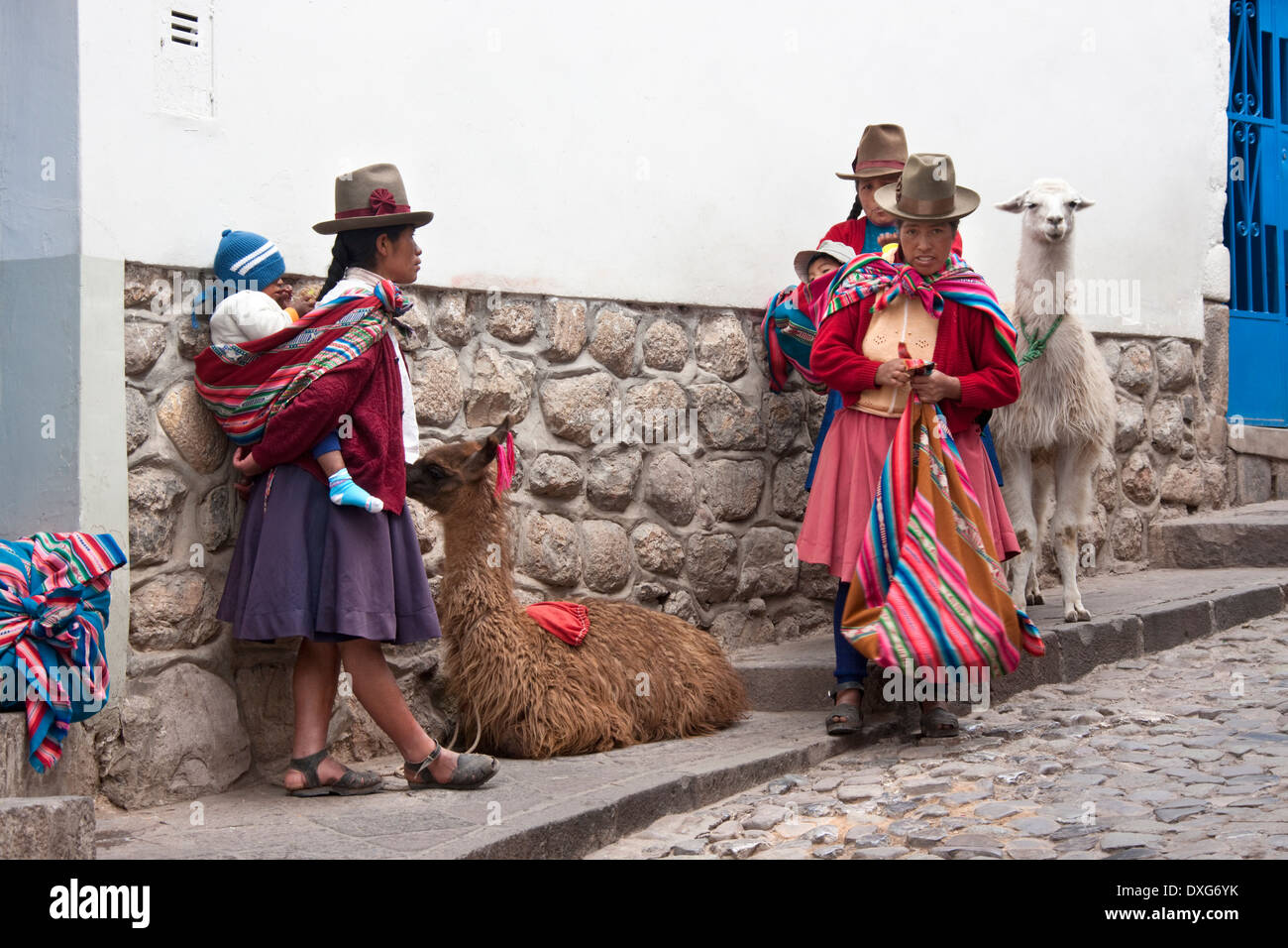 Peruanische Frauen mit Kindern und Lamas in der Stadt Cuzco in Peru, Südamerika. Stockfoto