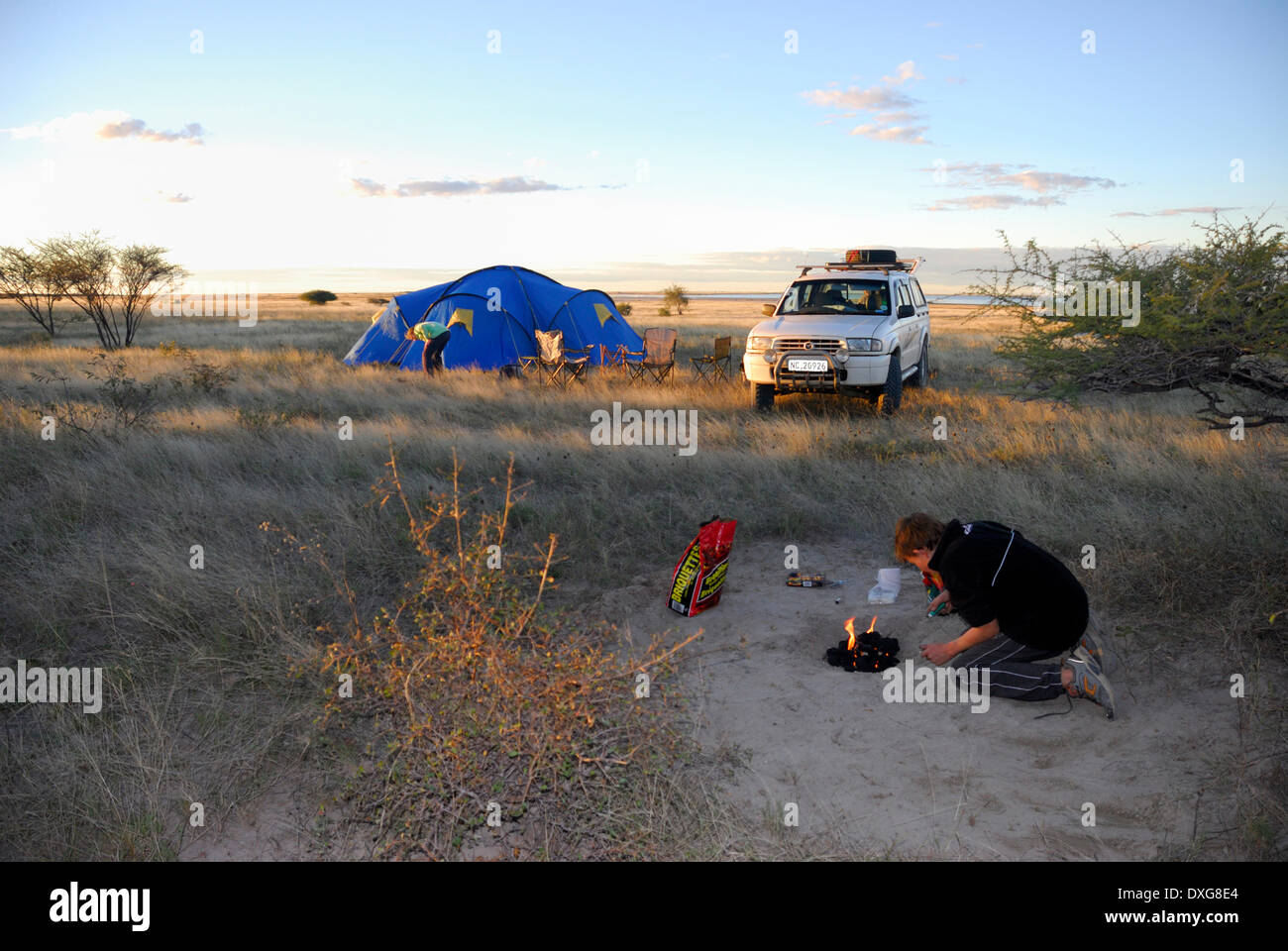 Beleuchtung ein Lagerfeuer und camping am Rande des überfluteten Sowa Pan in die Makgadikgadi Salzpfannen, Botswana. Stockfoto