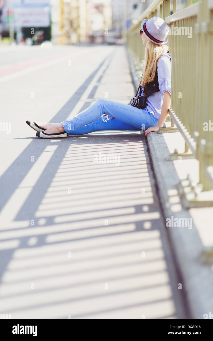 Junge Hipster sitzen auf Stadtstraße Stockfoto