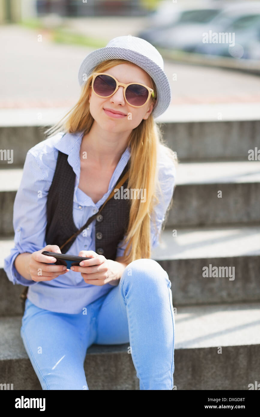 Portrait von junge Hipster sitzen auf Bank in der Stadt Stockfoto