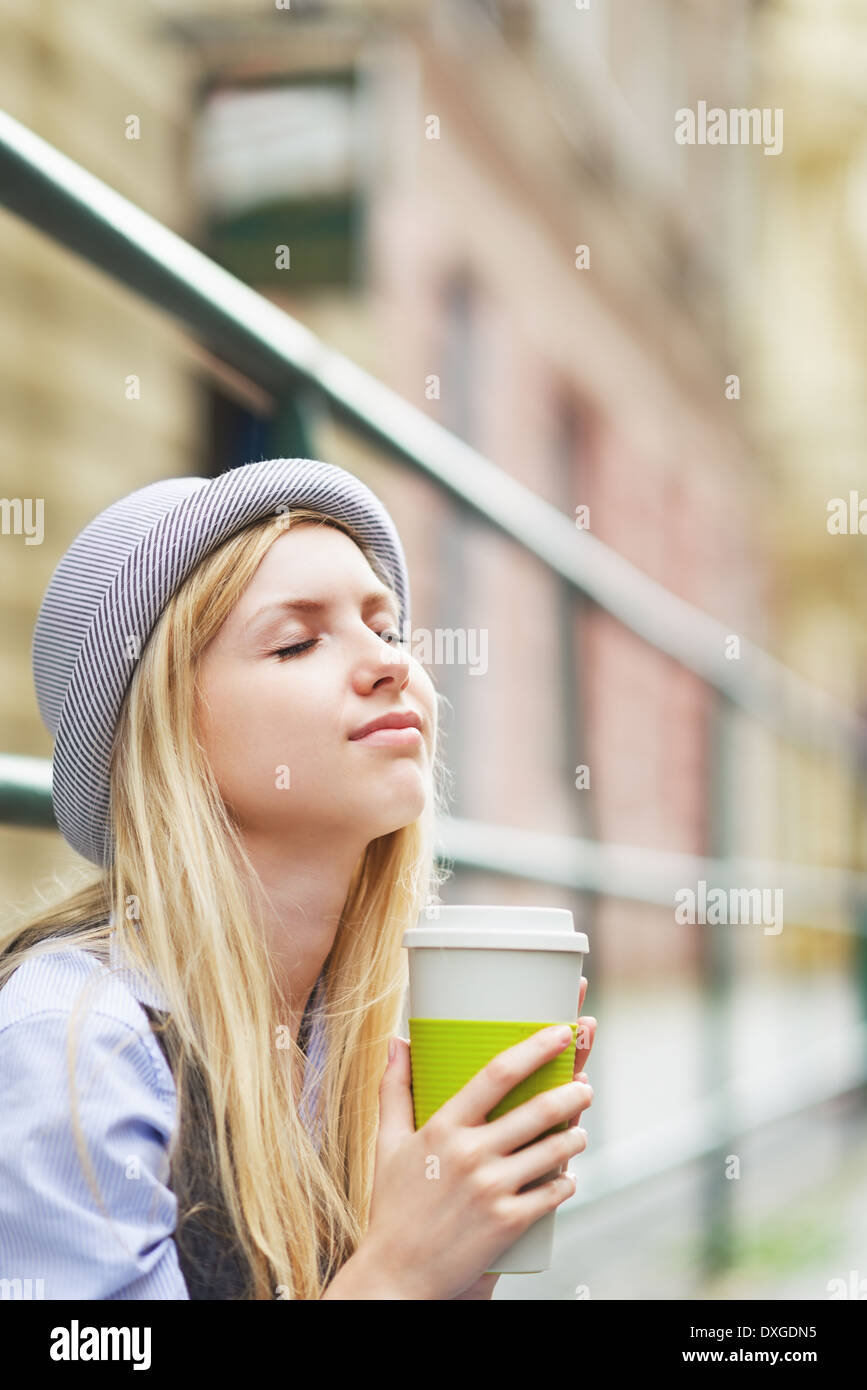 Junge Hipster Tasse Heißgetränk in der Stadt Stockfoto