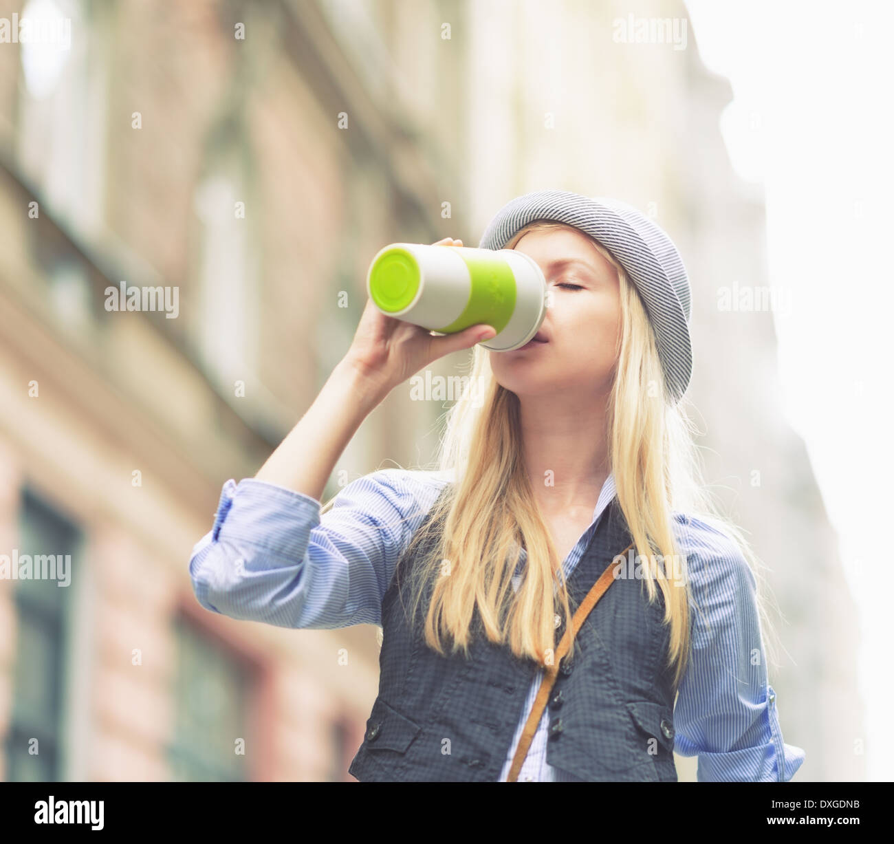 Junge Hipster Tasse Heißgetränk in der Stadt Stockfoto