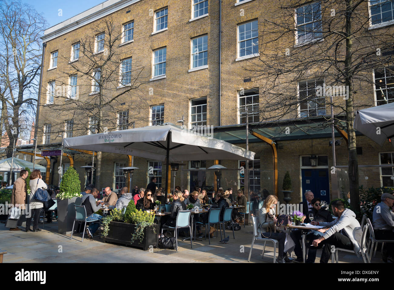 Menschen sitzen auf der Terrasse am Manicomio Restaurant und Café, Duke of York Square, Kings Road, Chelsea, London, UK Stockfoto