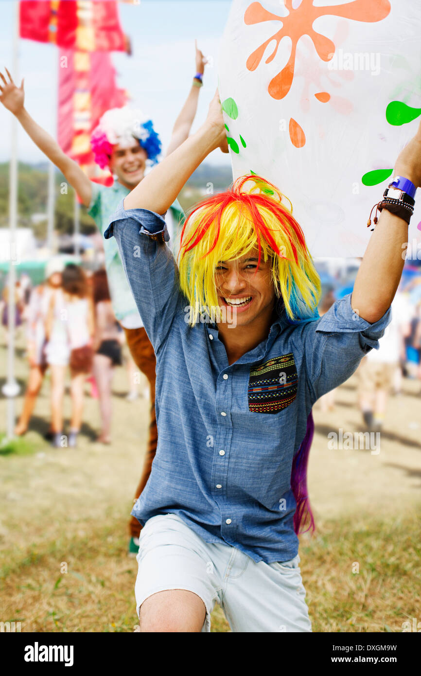 Verspielte Männer jubeln in Perücken beim Musikfestival Stockfoto