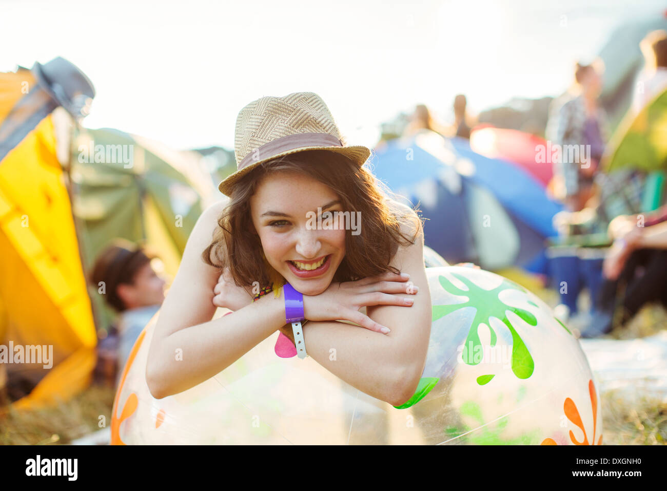 Porträt der lächelnde Frau stützte sich auf aufblasbarer Stuhl außerhalb Zelte beim Musikfestival Stockfoto