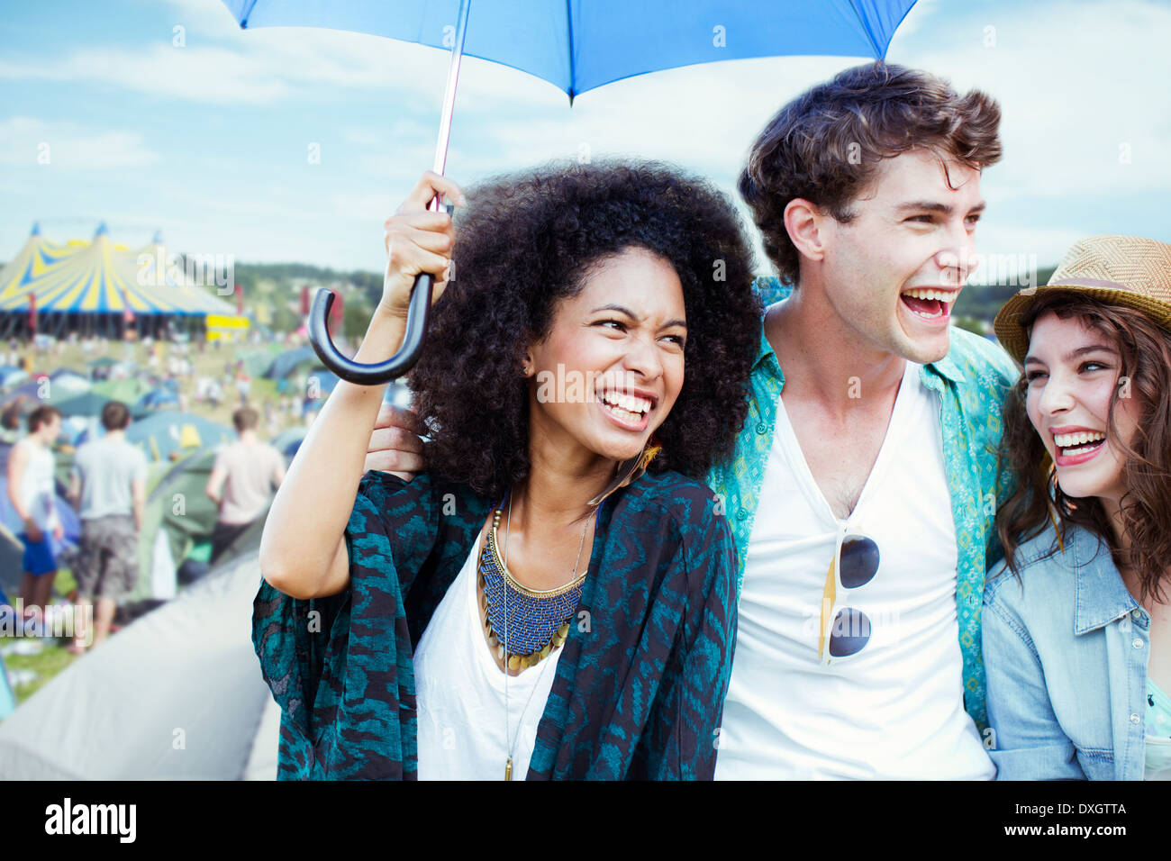 Freunde mit Regenschirm beim Musikfestival Stockfoto