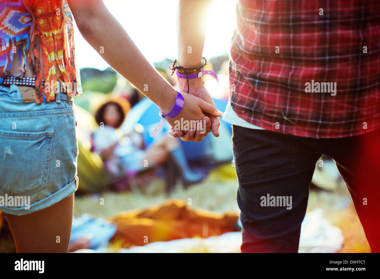 Nahaufnahme von paar Hand in Hand draußen Zelte beim Musikfestival Stockfoto