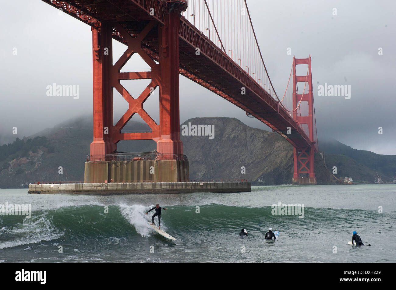 San Francisco, Kalifornien, USA. 25. März 2014. Surfer fangen Wellen unter der Golden Gate Bridge in San Francisco. Die Brücke, die 1937 eröffnete erstreckt sich über drei Meilen langen Kanal zwischen San Francisco Bay und dem Pazifischen Ozean. Bildnachweis: Robin Loznak/ZUMAPRESS.com/Alamy Live-Nachrichten Stockfoto