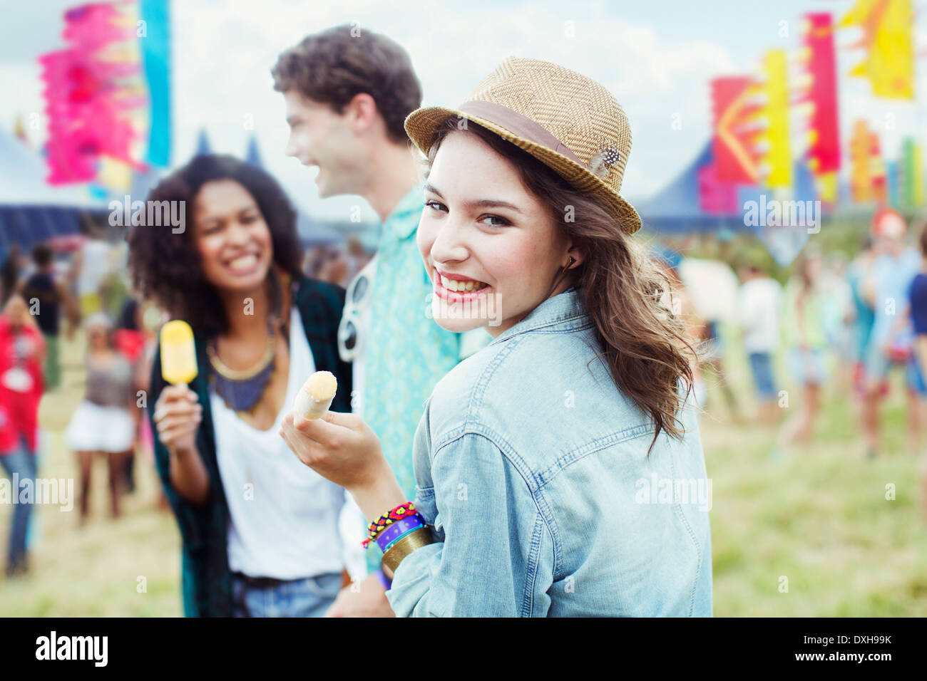 Porträt der Frau Essen aromatisierte Eis mit Freunden beim Musikfestival Stockfoto