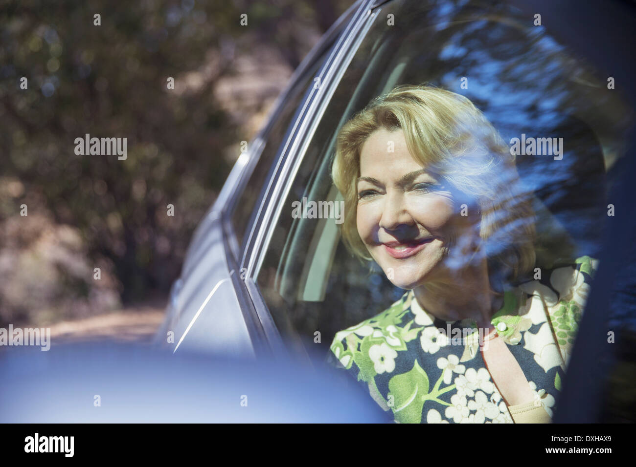 Glücklich senior Frau betrachten Autofenster Stockfoto