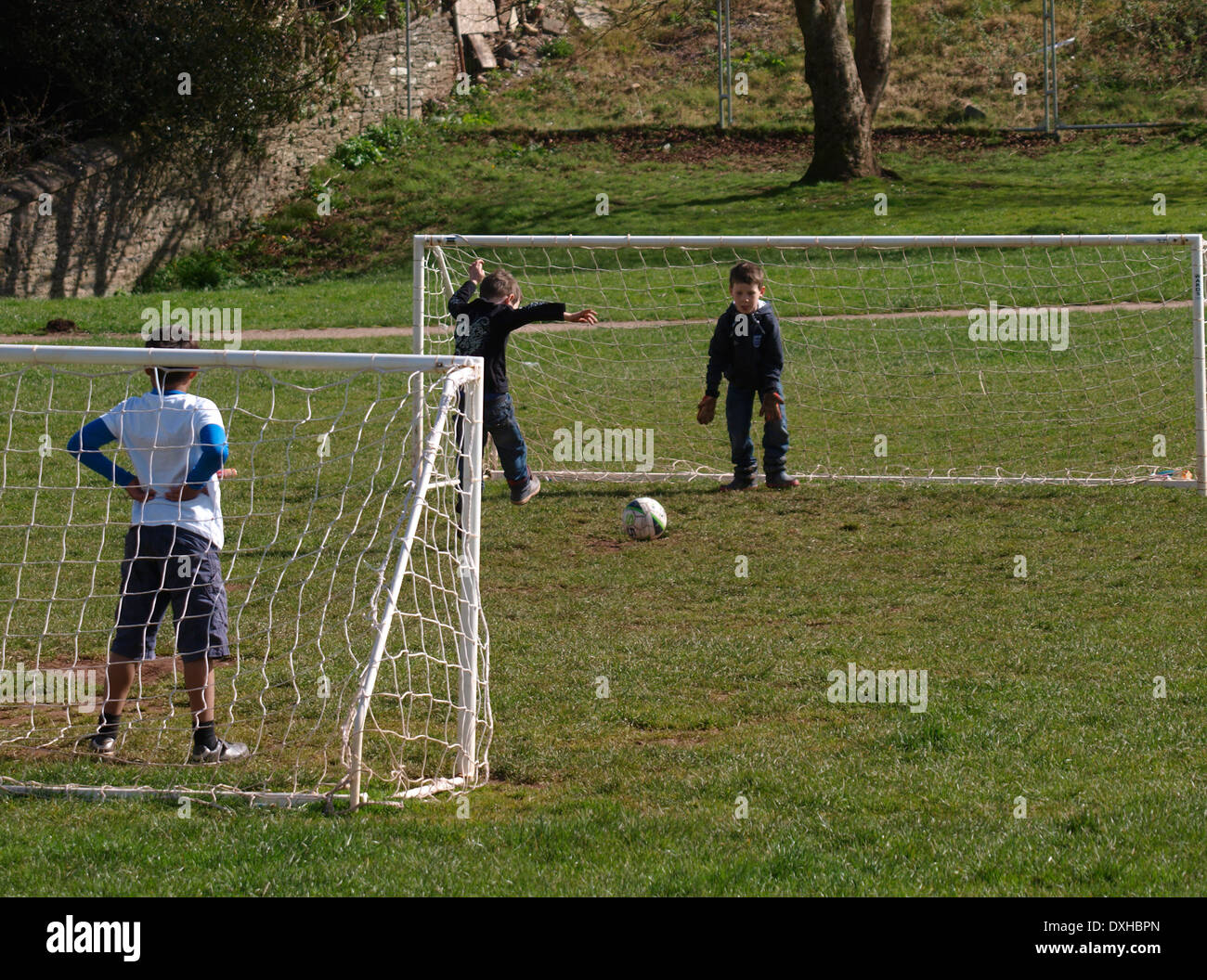 Jungen Fußball spielen in den Park, Kingsbridge, Devon, UK Stockfoto