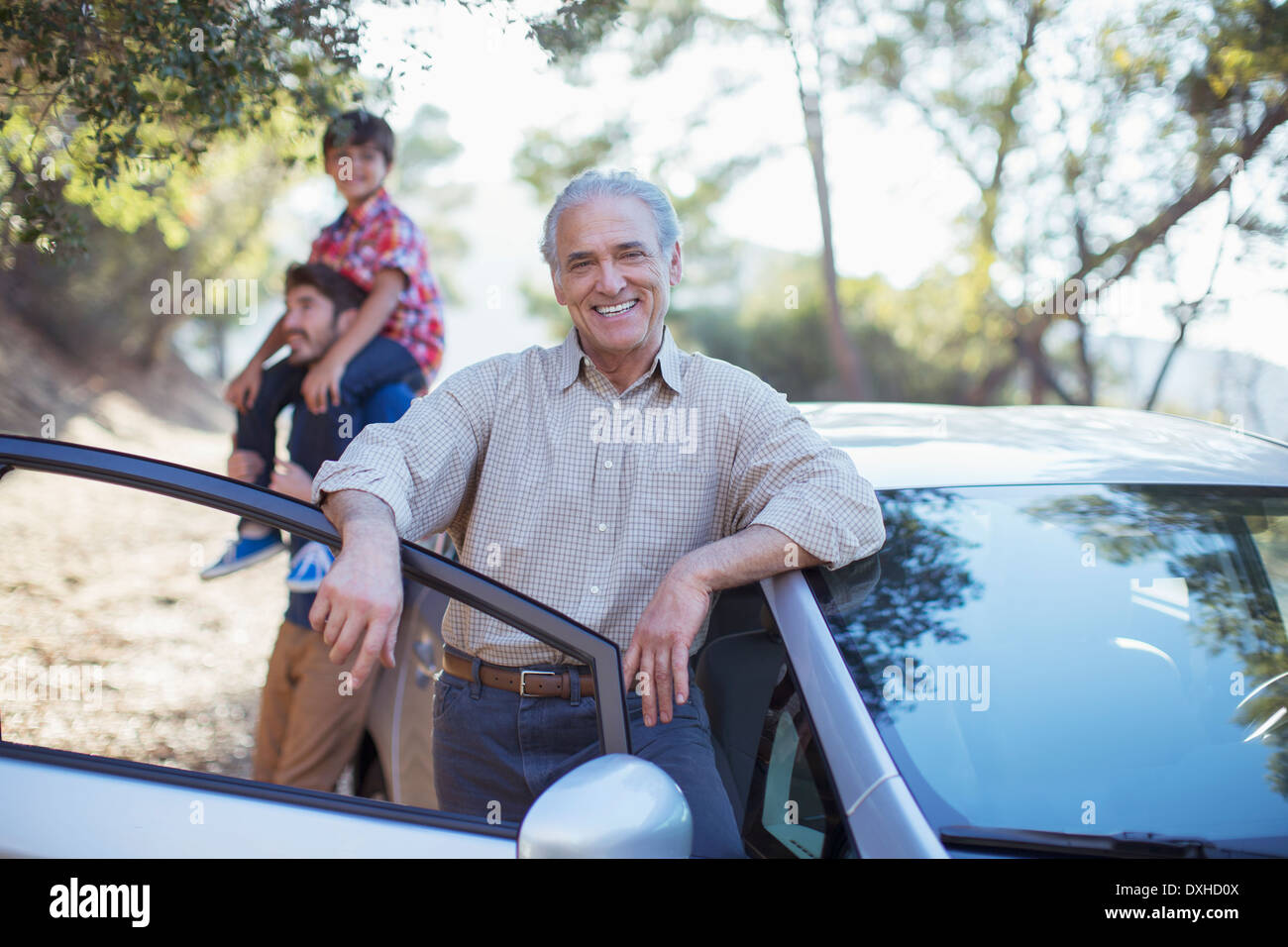 Portrait von senior Mann stützte sich auf Auto Stockfoto