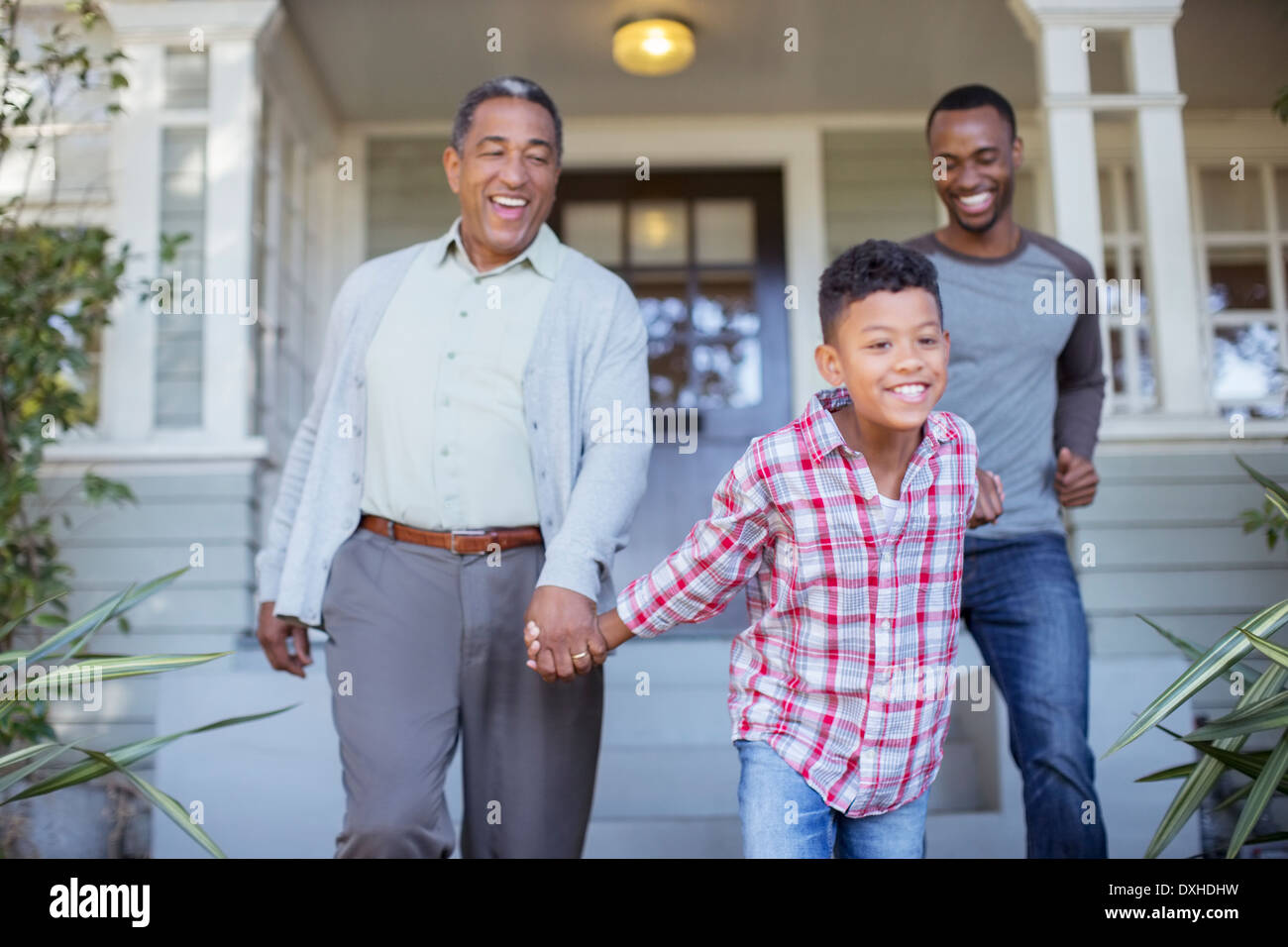 Generationsübergreifende Männer Hand in Hand vor Haus Stockfoto