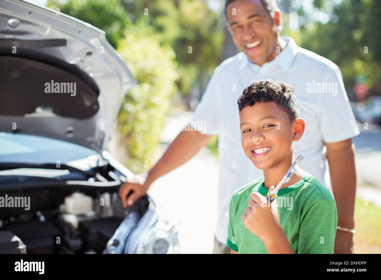 Porträt von lächelnden Enkel Reparatur Automotor mit Großvater Stockfoto