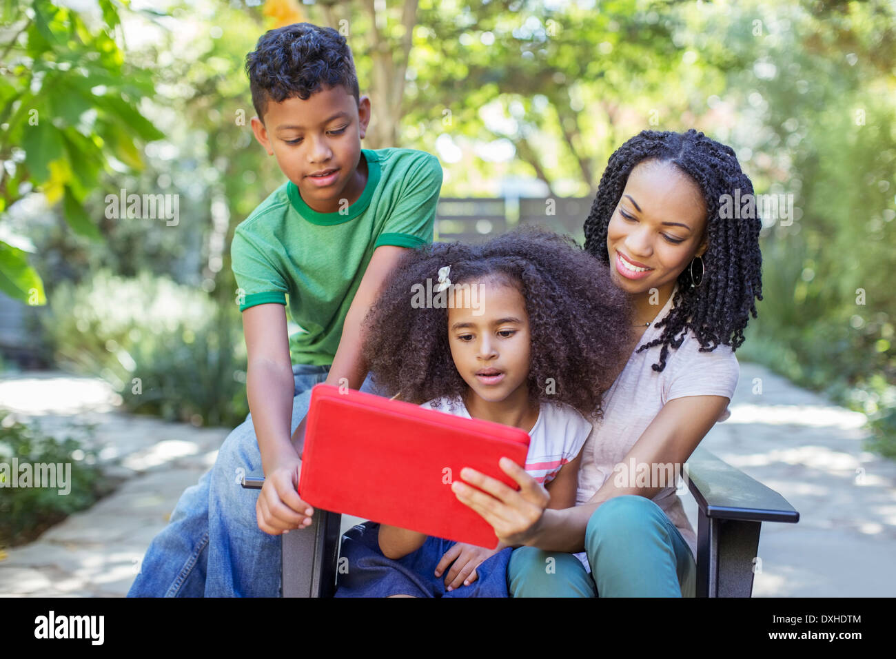 Mutter und Kinder bei der Nutzung digitalen Tablets im freien Stockfoto