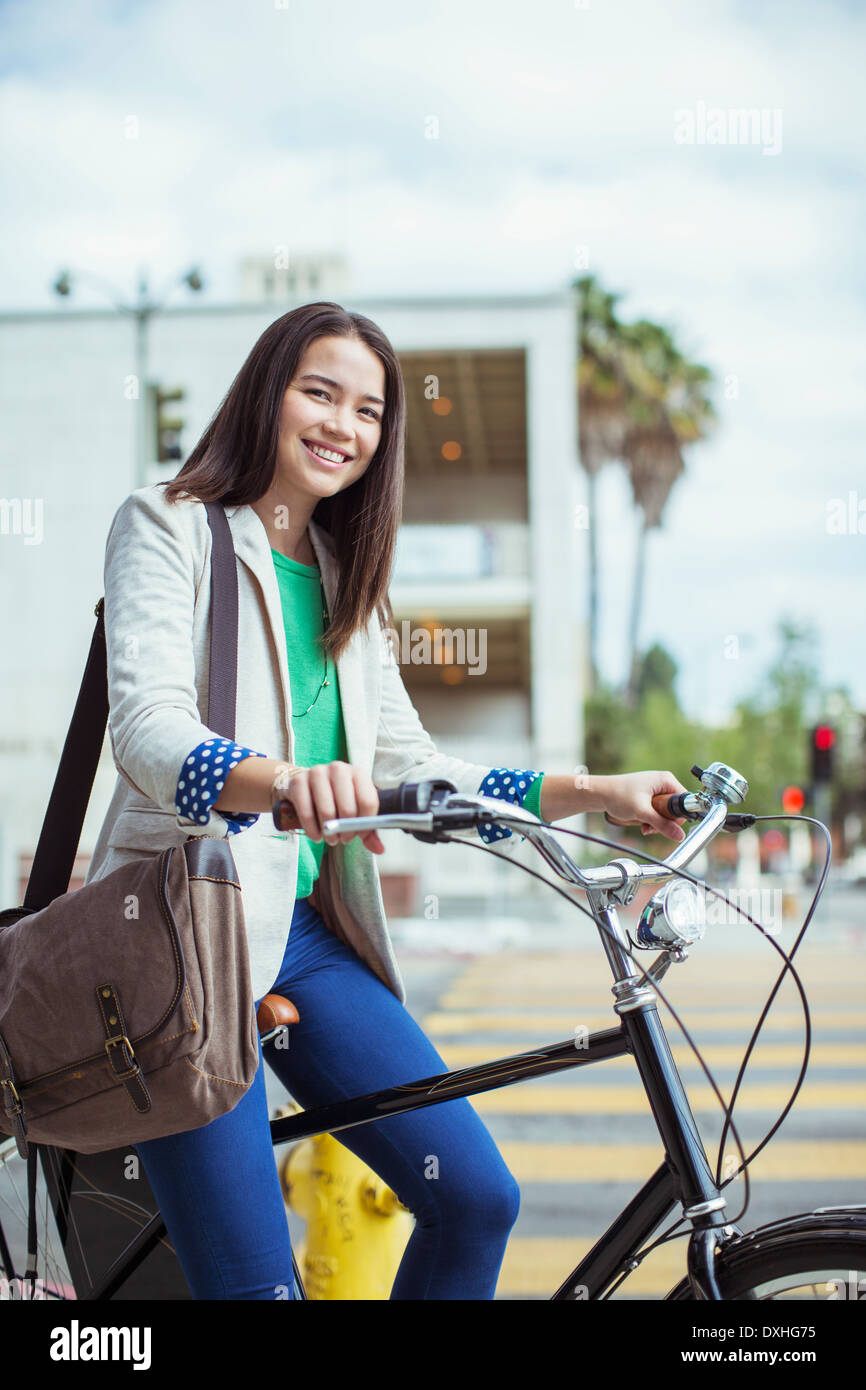 Porträt von lächelnden lässig Geschäftsfrau mit dem Fahrrad auf der urban street Stockfoto