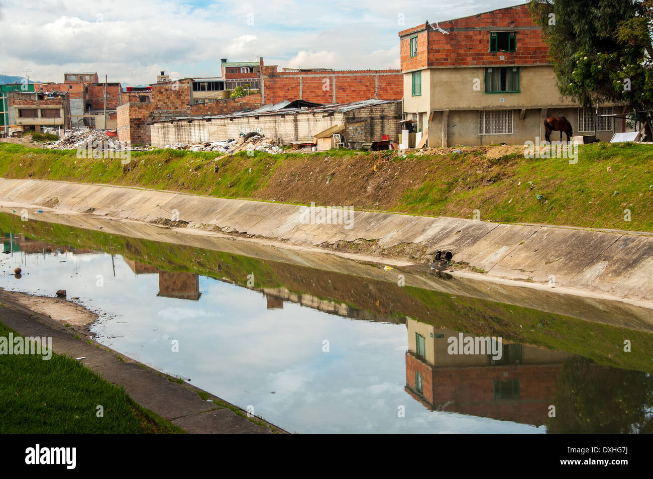 Eine niedrigeren Klasse Nachbarschaft spiegelt sich in einem Fluss in Bogota, Kolumbien Stockfoto