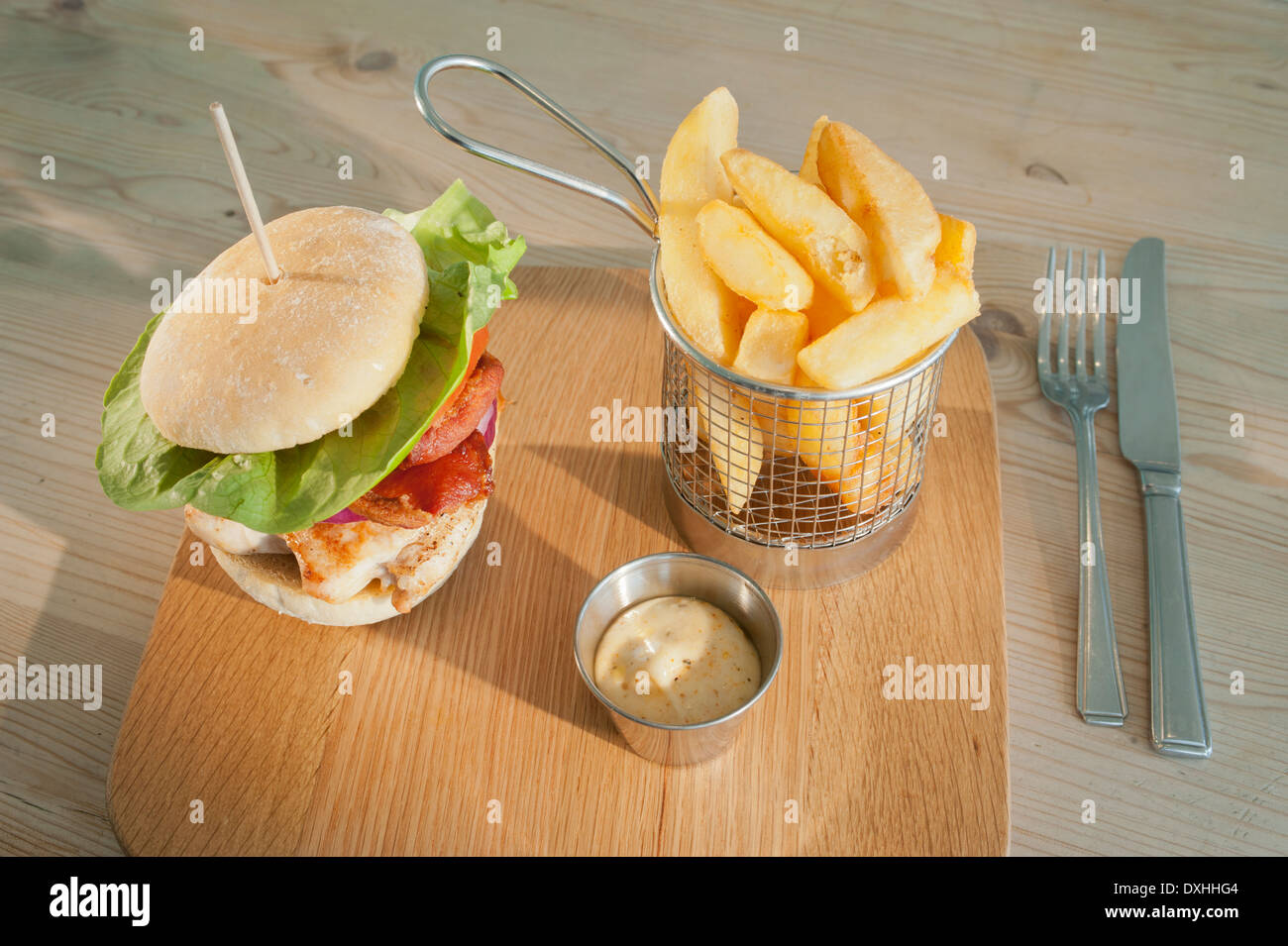 Hähnchen-Speck-Burger mit Beilagen von Mayonnaise und Französisch gebraten oder Kartoffeln gesäumt. (Pommes frites oder Chips) Stockfoto