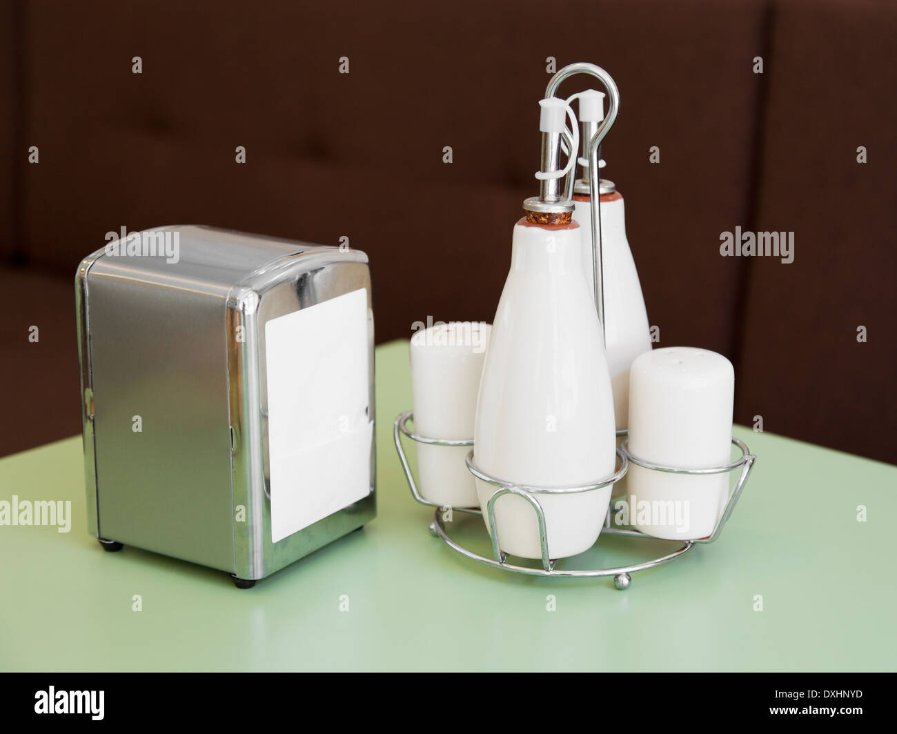 Pfeffer und Salzstreuer, Flaschen für Öl und Essig, Serviettenhalter - set Café Tischplatte Stockfoto