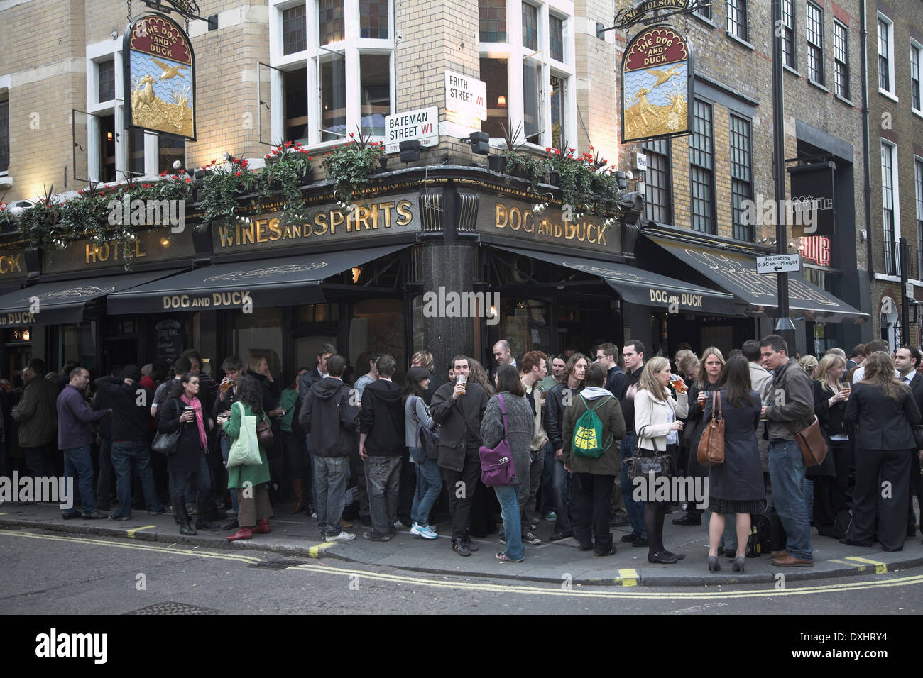 Trinker spill heraus auf der Straße vor dem Hund und Ente Pub in Soho, London, England Stockfoto