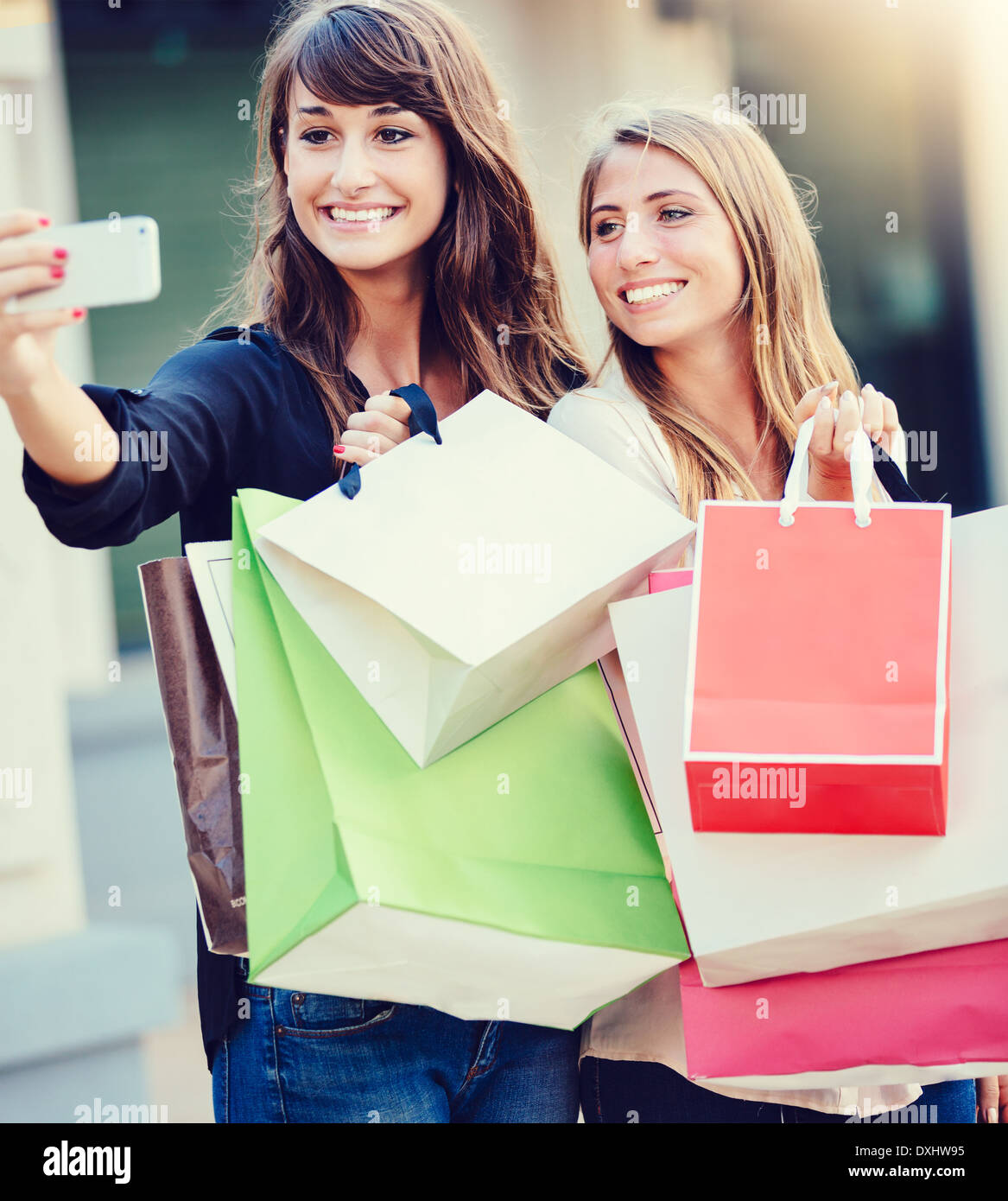 Schöne Mädchen mit Einkaufstüten, die unter einem "Selfie" mit ihrem Handy Stockfoto