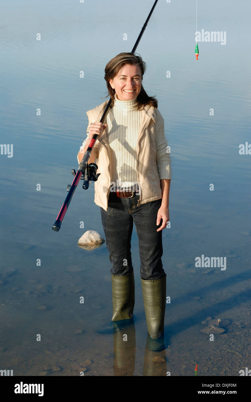 Frau mit Angelrute in See Porträt stehen erhöht, Ansicht Stockfoto