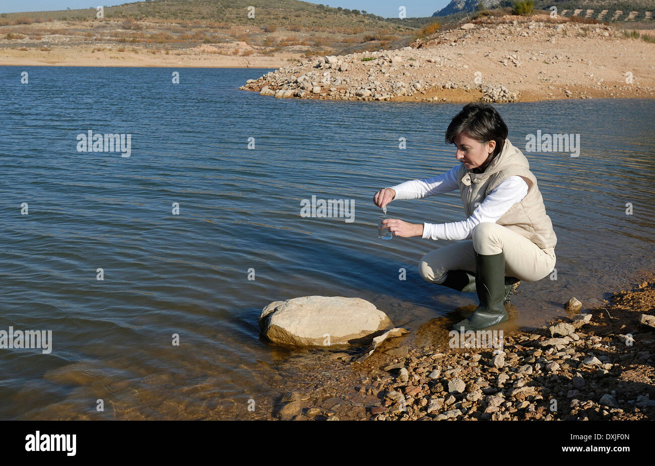 Wissenschaftlerin Probenahme Wasser von See-Seitenansicht Stockfoto