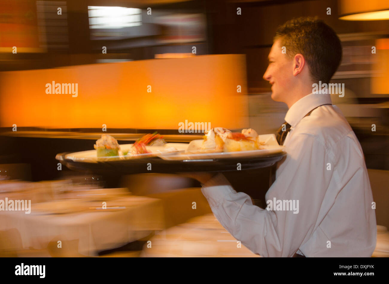 Kellner mit Tablett mit Geschirr über Restaurant Stockfoto