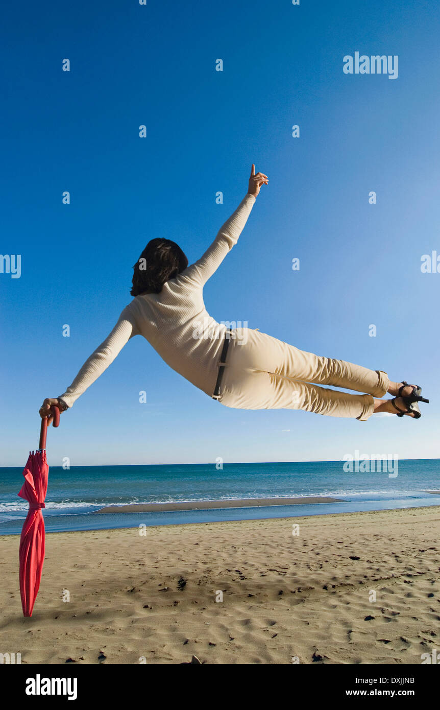 Frau Luft am Strand stützte sich auf Dach Sicht nach hinten springen Stockfoto