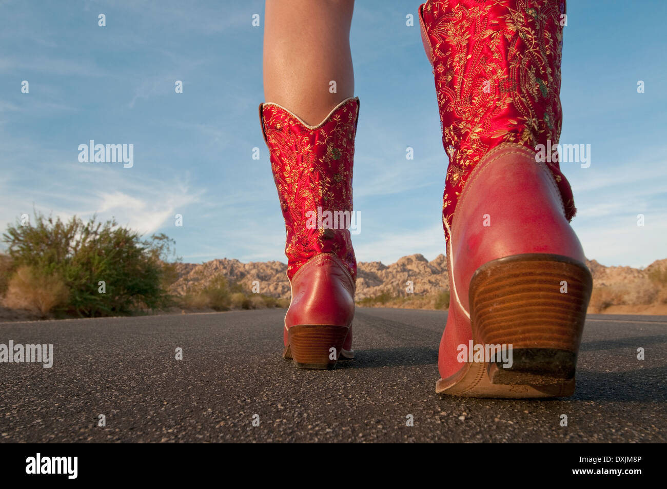 Frau in roten Stiefeln zu Fuß zum Horizont Stockfoto