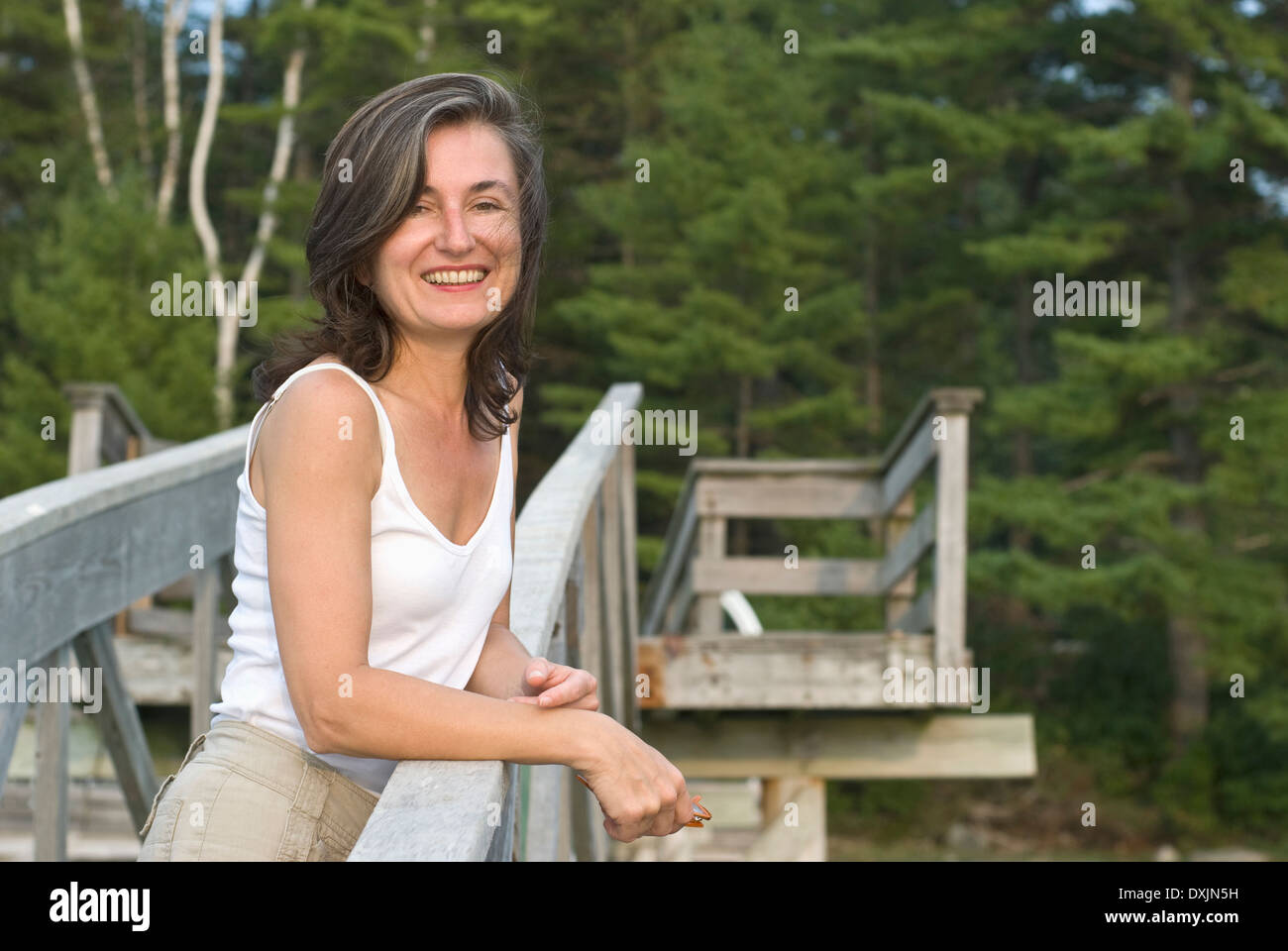 lächelnde Frau am Holzsteg Stockfoto